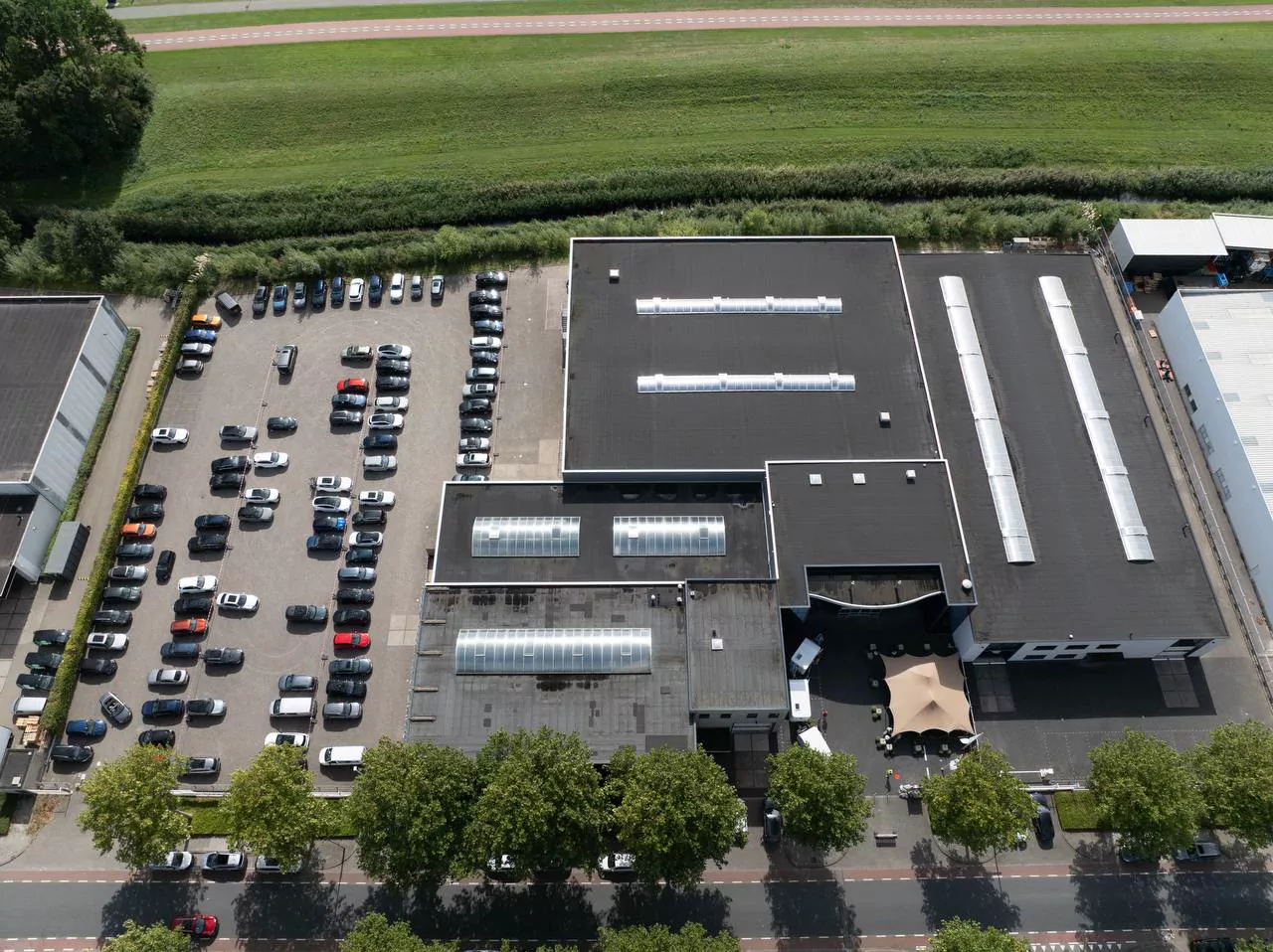 Bedrijfspand van Hobby en volledig parkeerterrein recht van boven op circa 100 meter hoogte